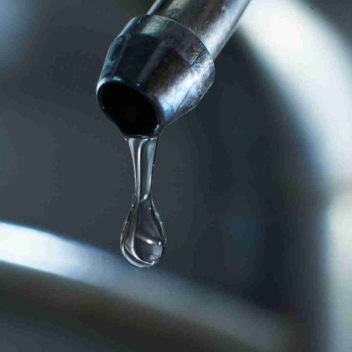 Reverse osmosis filter tap closeup with dripping water-drop.