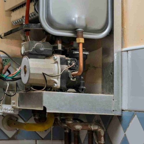 Water heater maintenance service technician repairing gas water heater